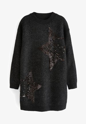 Sort langærmet strikket sweater med metallisk tråd og to store sorte palietstjerne-mønstre, en nær brystet og en nær kanten.