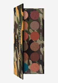 Kamouflage Lidschattenpalette mit neun runden Pans in verschiedenen Finishes. Die Farben umfassen Brauntöne, Grüntöne und einen Akzent in Türkis. Strukturierte Verpackung.