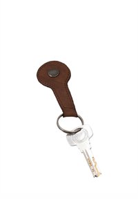 Clé argentée attachée à un porte-clés rond en cuir marron avec un bouton métallique sur fond blanc.