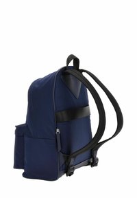 Sac à dos en tissu bleu marine avec bretelles rembourrées, poche latérale et finitions en cuir. Design élégant et structuré avec un compartiment zippé.