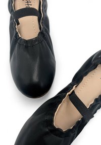 Ballerine in pelle nera con punta tonda, cinturino elastico e bordo arricciato, caratterizzate da una texture liscia e una soletta beige.