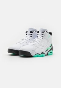 Sneaker alte bianche con dettagli neri e suola verde menta. Presentano una parte superiore strutturata, un sistema di allacciatura e dettagli del logo sui lati.