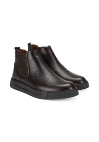 Bottes ankle en cuir marron avec finition texturée, panneaux latéraux élastiques et semelle en caoutchouc noir contrastante. Design moderne et épuré sans lacets visibles.