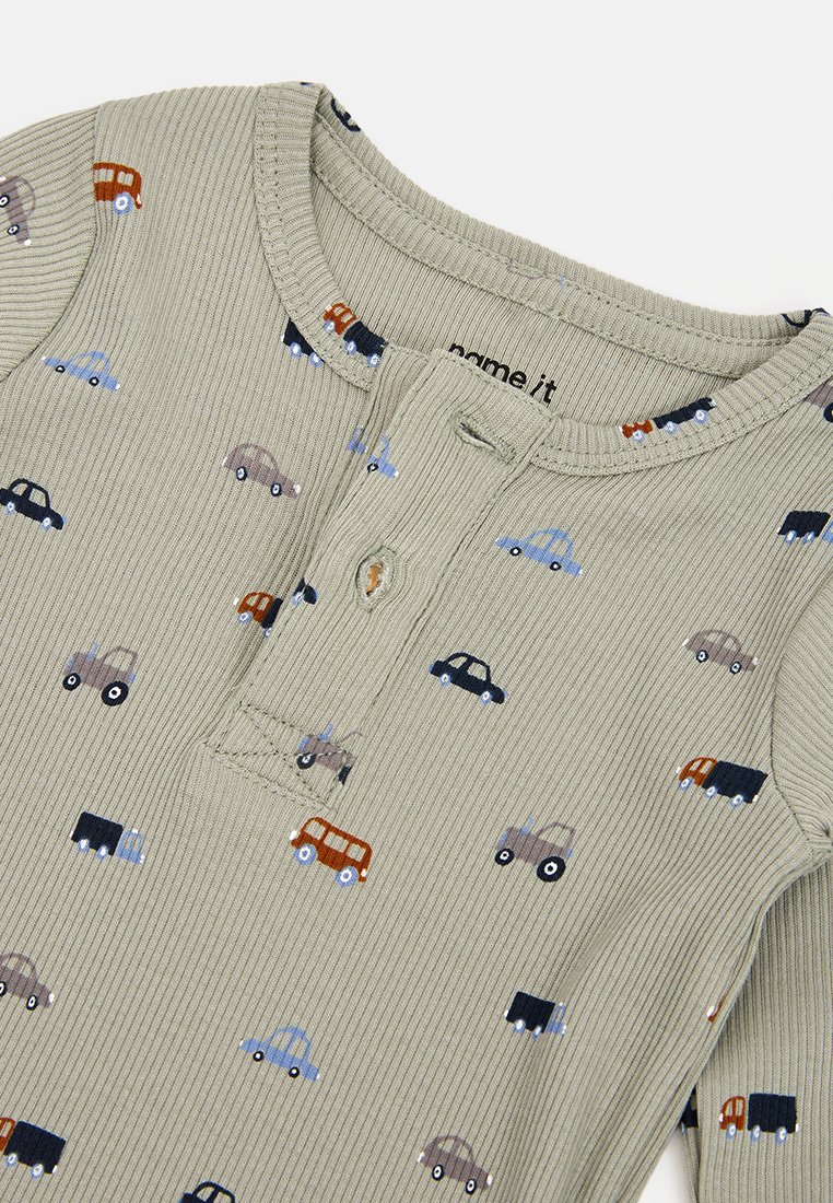 Hellolivgrünes geripptes Langarmshirt mit Knopfleiste und kleinen farbenfrohen Auto-Drucken in verschiedenen Stilen und Farben.