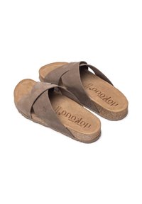 Sandales en suede marron avec des sangles croisées, semelle en liège, semelle en caoutchouc texturé et logo embossé sur la semelle intérieure.