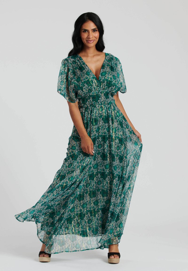 Robe maxi verte avec imprimé floral, dotée d'un décolleté en V profond, de manches bouffantes courtes, d'une taille cintrée et d'une jupe fluide. Tissu lisse et léger.