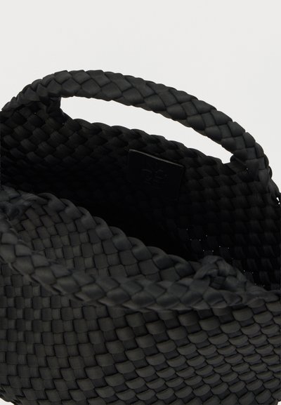 Μαύρη υφασμάτινη τσάντα καλαθιού με λεία υφή, διαθέτει πλεκτή λαβή και ετικέτα στο εσωτερικό. Συμπαγής σχεδιασμός κατάλληλος για διάφορες χρήσεις.