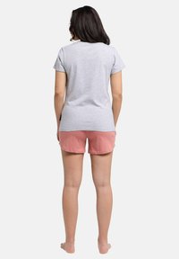 Grå bomulds t-shirt med korte ærmer, parret med lyserøde bomulds shorts. Outfittet har en afslappet pasform og blød tekstur.