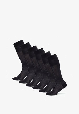 Sechs Paar schwarze kniehohe Feinsocken mit verstärkten Zehen und Bündchen, in einer Reihe auf weißem Hintergrund angeordnet.