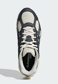 Čierne a krémové tenisky s textilným zvrškom, polstrovaným golierom, šnúrkami a značkou "CLOUDFOAM" na vložke. Textúrovaná gumová podrážka.