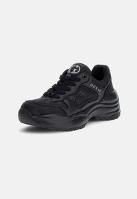 Zapatillas Guess negras con parte superior de cuero texturizado, diseño con cordones, puntera redonda y suela de goma gruesa. Presenta un logotipo y patrones sutiles.
