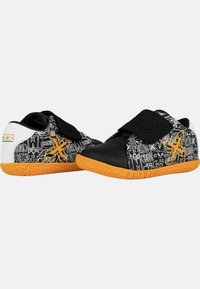 Zapatos negros y naranjas con patrones gráficos, correas de velcro y suelas de goma texturizadas. Los acentos blancos en el talón completan el diseño.