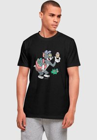 Black cotton t-shirt featuring a cartoon character holding Easter eggs, with a colorful basket on its back. Classic, vibrant graphic design.