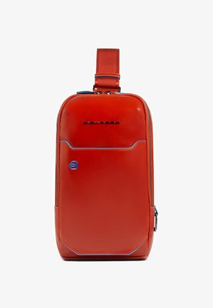 Roter synthetischer Rucksack mit rechteckiger Form, blauen Akzenten, vorderer Reißverschlusstasche und verstellbarem Gurt. Logo ist oben angebracht.