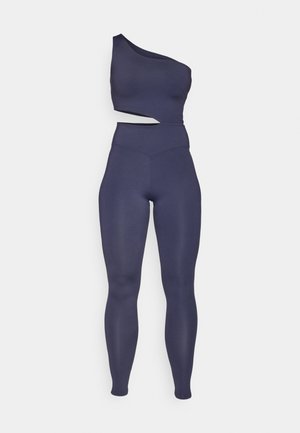 Navy one-shoulder crop top paired with high-waisted leggings, form-fitting design, smooth texture, and no visible patterns or hardware.