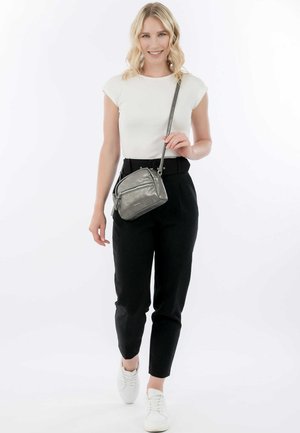 Silberne Umhängetasche mit mehreren Reißverschlussfächern. Glatte metallische Oberfläche, verstellbarer Tragegurt und ein kleines Logodetail auf der Vorderseite.