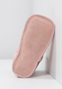 Weiche rosa Hausschuhe mit einer strukturierten Suede-Oberfläche und einem kontrastierenden gestickten Rand. Konturierte Form für Komfort, ideal für den Innenbereich.