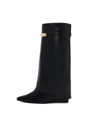 Bota alta de cuero negro con punta afilada y una correa delgada con un pequeño detalle metálico dorado cerca de la parte superior.