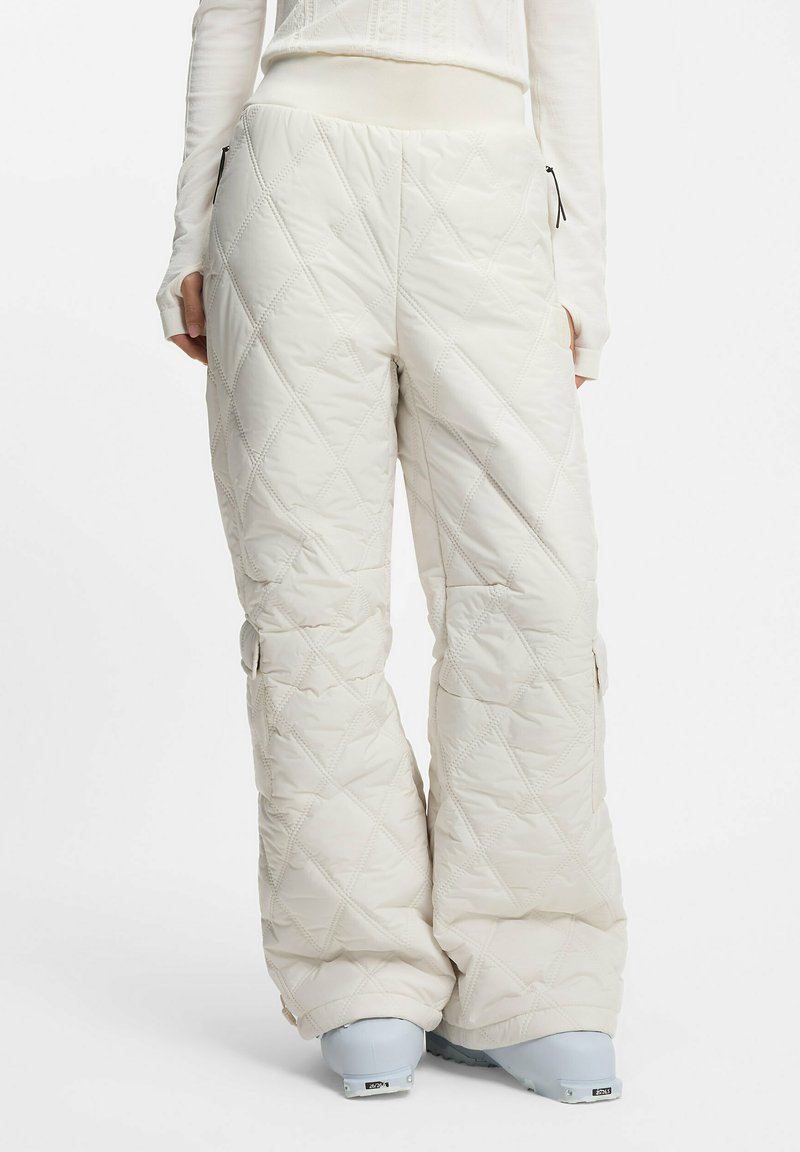 Białe pikowane spodnie śniegowe z wysokim elastycznym pasem, bocznymi kieszeniami i luźnym krojem. Materiał wydaje się miękki, z delikatnym połyskiem.