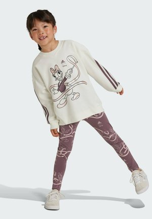 Felpa bianca con stampa di un personaggio dei cartoni animati, dettagli viola e leggings viola coordinati con un motivo. Sneakers bianche con lacci completano l'outfit.