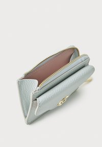 Portefeuille en cuir bleu clair avec une finition texturée, doté d'une fermeture éclair dorée, d'une doublure rose et de plusieurs compartiments pour cartes et billets.