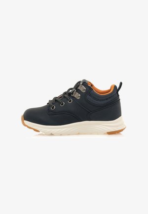 Zapatillas deportivas azul marino con una parte superior sintética suave, detalles reflectantes, forro naranja y una suela de goma blanca y texturizada.