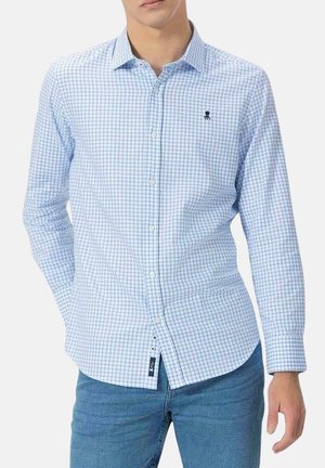 Camisa de cuadros en tonos azul claro y blanco, de botonadura y mangas largas. Presenta un pequeño logo bordado y un dobladillo curvado. Tejido de mezcla de algodón.