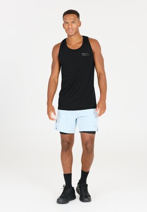Sort tanktop, lyseblå shorts med sideslidser, sorte sokker og sorte sneakers. Tanktoppen har subtile hvide linje accenter.