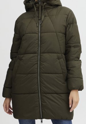 Kobieta w oliwkowozielonej pikowanej długiej kurtce puchowej z kapturem, zamkiem błyskawicznym z przodu i bocznymi kieszeniami, pokazana od ramion do połowy uda.