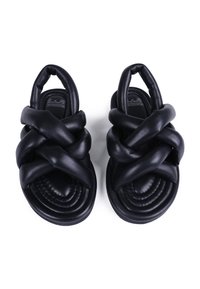 Sandalias negras con un diseño de tiras entrelazadas y acolchadas. Las suelas de goma tienen una textura estriada, ofreciendo un ajuste ceñido y comodidad.