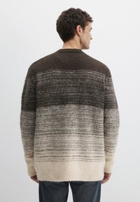 Gestrickter Pullover mit einem Farbverlauf in Dunkelbraun, Grau und Creme, mit lockerem Schnitt und langen Ärmeln. Weiches, strukturiertes Wollmaterial.