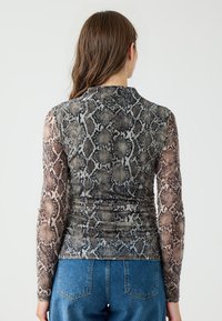 Langärmliges Oberteil mit einem transparenten Schlangenmuster in Grautönen und Brauntönen, das einen figurbetonten Schnitt und gerüschte Details an der Taille aufweist.