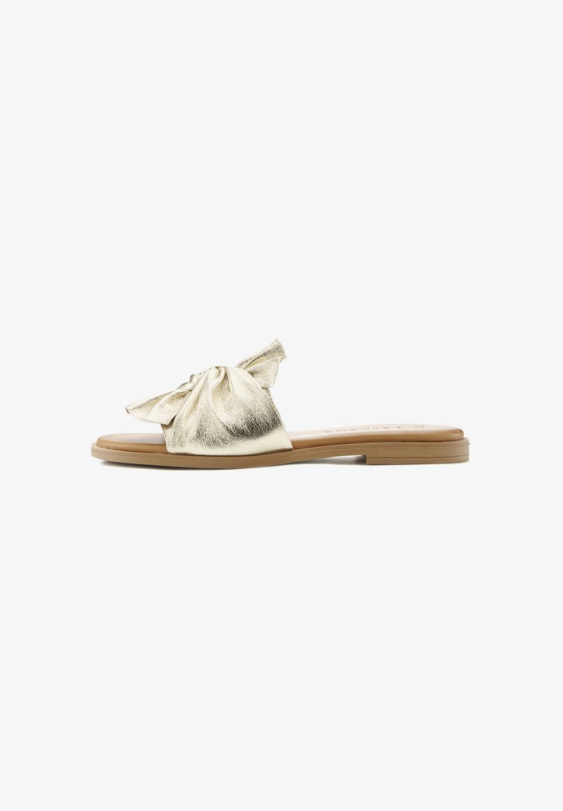 Gold metallic slide sandal with a bow detail on the upper, flat sole, and a smooth texture. Features a light brown outsole.