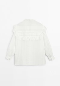 Witte blouse met lange mouwen met gerimpelde inzet en geborduurde horizontale strepen, van achteren gezien tegen een effen achtergrond.