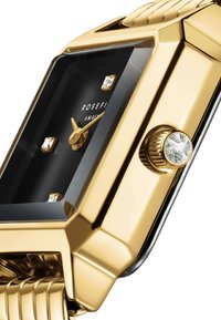 Reloj rectangular en tono dorado con esfera negra, que presenta cuatro marcadores de hora similares a diamantes, manecillas doradas y un acento texturizado en la corona.