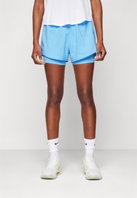 Pantalones cortos deportivos azules con un diseño ligero, que cuentan con una cintura elástica y un aspecto en capas. Se llevan con calcetines blancos hasta el tobillo y zapatillas deportivas.