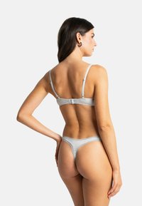 Ensemble soutiens-gorge et string en coton gris avec bretelles réglables, détails en dentelle et conception sans coutures pour un confort optimal. Vue de dos affichée.