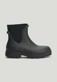Black rubber Chelsea boot with a textured finish, featuring a solid color design and green accents. Thick, rugged sole for grip.