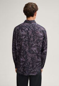 Langarmhemd aus gemustertem Stoff, mit floralen Designs in Dunkelviolett und Schwarz. Glatte Textur mit klassischem Kragen und geknöpften Manschetten.