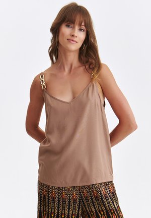 Brązowy satynowy top na ramiączkach z dekoltem w serek i detalami z złocistymi akcentami na regulowanych ramiączkach. Gładka tekstura, w połączeniu z wzorzystymi spodniami.