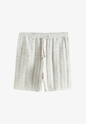 Lys beige strikkede shorts med lodrette åbne strikstriber, elastisk talje og snorbindelukning på hvid baggrund.