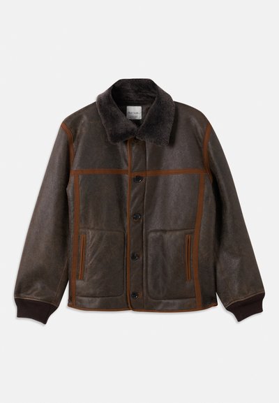 Καφέ δερμάτινο μπουφάν με μαλακό σκούρο γιακά, αντίθετη καφέ ραφή, κούμπωμα με κουμπιά και δύο μπροστινές τσέπες. Ραμμένα μανίκια και στρίφωμα.