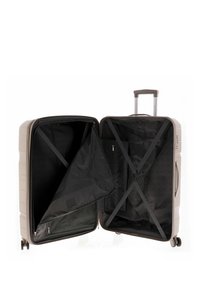 Maleta rígida en gris claro, con un acabado mate, compartimentos con cremallera, forro interior negro y correas cruzadas para asegurar los objetos.