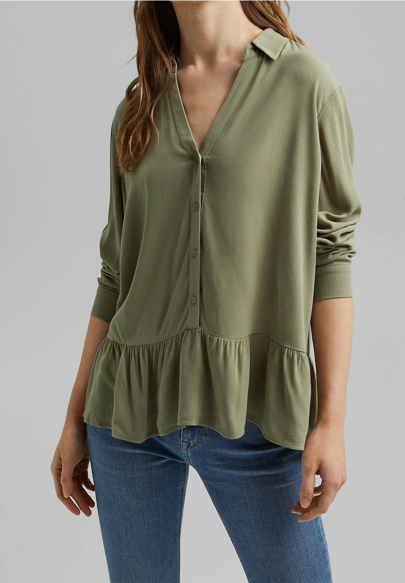 Blusa verde oliva con bottoni, colletto, maniche lunghe e orlo arricciato. Realizzata in tessuto leggero con una texture liscia.