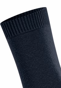 Calza lavorata a maglia di un blu navy scuro con bordo a costine, mostrata da vicino su uno sfondo bianco.