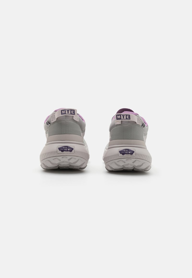 Zapatillas grises y lavanda con un talón acolchado, parte superior de tela, suela texturizada y marca en la parte trasera. Punta redondeada con un diseño de soporte.