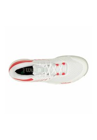 Zapatilla deportiva blanca con acentos rojos, parte superior de malla para mayor transpirabilidad, cordones planos y suela texturizada. Presenta la marca 'Wilson' cerca del talón.