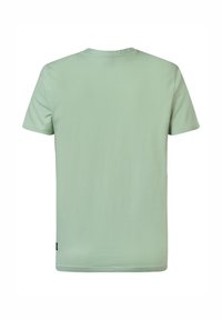 Camiseta de manga corta verde claro, hecha de tela suave, con un cuello redondo clásico y sin patrones ni acentos visibles. Solo vista desde atrás.