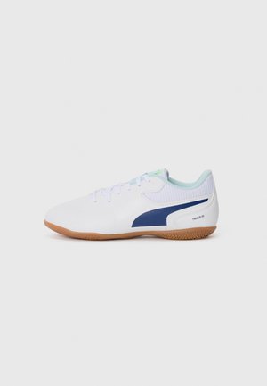 Chaussure de sport blanche avec un accent bleu marine, tige en maille texturée, col bleu clair et semelle en caoutchouc. Présente un design minimaliste et des lacets.