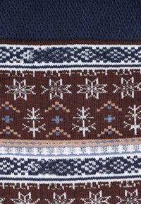 Dzianinowy sweter z granatową górną częścią oraz brązową dolną częścią ozdobioną białymi, niebieskimi i beżowymi wzorami płatków śniegu i geometrycznymi.